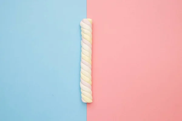 Farbige lange Marshmallows auf rosa und blauem Hintergrund, köstliche Süßigkeiten flach gelegt — Stockfoto