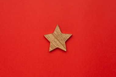 Kırmızı arka planda Noel ağacı için ahşap süsleme yıldızı