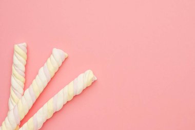 Renkli uzun marşmelovlu pembe arka plan, leziz tatlılar bembeyaz.