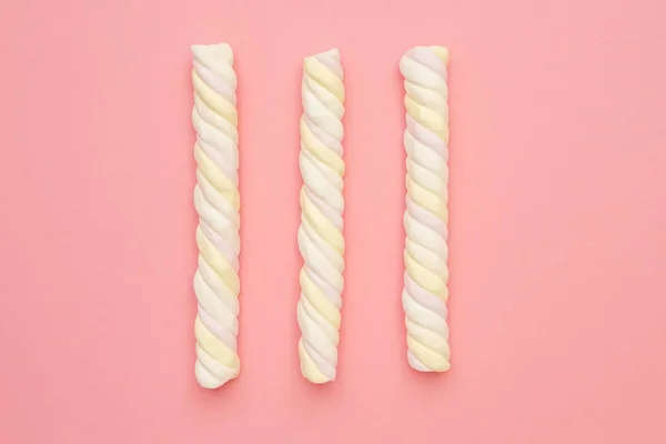 Farbige lange Marshmallows auf rosa Hintergrund, köstliche Süßigkeiten flach gelegt — Stockfoto