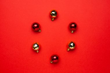 Kırmızı arka planda kırmızı ve altın Noel süslemeleri.