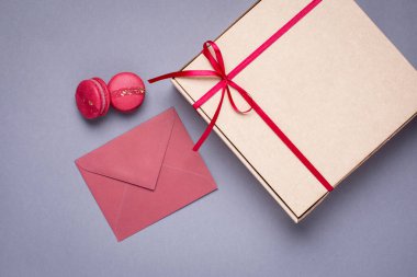 Gri arkaplanda bordo saten kurdeleyle kutuda hediye