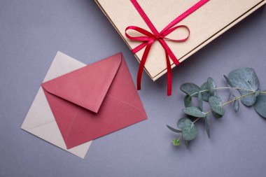 Şimdiki kart ve hediye paketi içinde gri arka planda saten kurdele