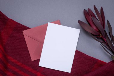 Gri arkaplanda hediye kartı ve bordo ambalaj kağıdı.