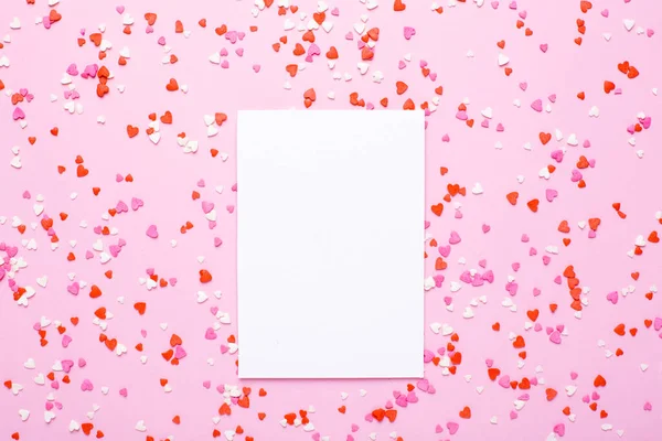 Подарункова листівка з рожевими, червоними серцями на рожевому фоні — стокове фото
