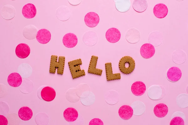 Buchstaben Kekse hallo mit Konfetti auf rosa Hintergrund — Stockfoto