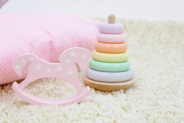 Çocuklar oyuncak gökkuşağı renkli piramit ve parlak arka planda pembe oyuncak at