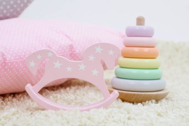 Çocuklar oyuncak gökkuşağı renkli piramit ve parlak arka planda pembe oyuncak at