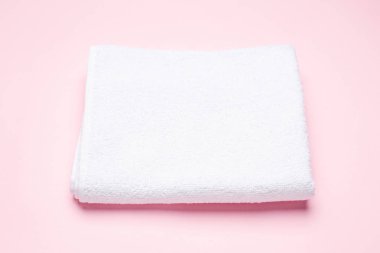 Pembe arka planda beyaz banyo havlusu, banyo ve kaplıca aksesuarı.