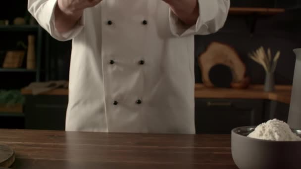 男性シェフは台所で小麦粉で生地を準備します パン生地は小麦粉を振りかけ スローモーション側のビューで調理 — ストック動画