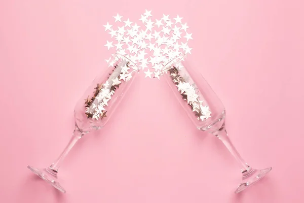 Gümüş yıldızlı şampanya bardakları pembe renkli kağıt kaplamalı konfeti.