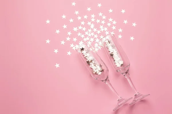 Gümüş yıldızlı şampanya bardakları pembe renkli kağıt kaplamalı konfeti.