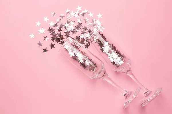 Champagnergläser mit silbernen rosa Sternen Konfetti auf rosa Farbpapier Hintergrund minimalen Stil — Stockfoto