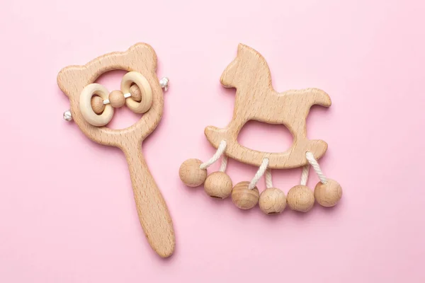 Pembe arka planda bebek ahşap çıngıraklar ve oyuncaklar izole