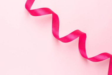 Pembe arka planda hediye kurdele fuşya rengi. Tatiller için minimalist kompozisyon.