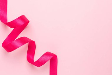 Pembe arka planda hediye kurdele fuşya rengi. Tatiller için minimalist kompozisyon.