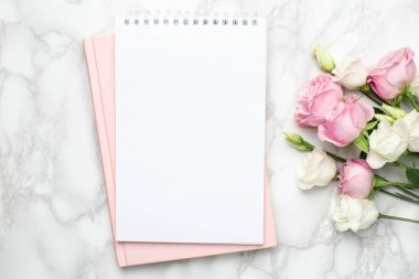 Güzel beyaz ve pembe güller çiçek ve mermer arka planda defter