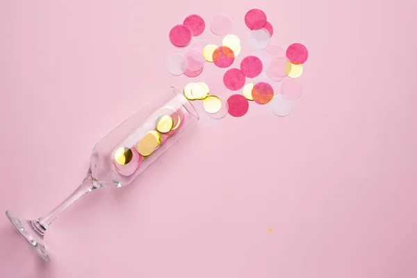 Champagnerglas mit goldenem und rosa Konfetti auf rosa Farbpapier Hintergrund minimalen Stil — Stockfoto