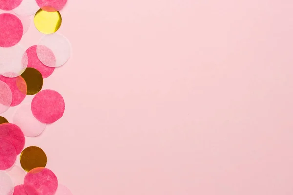 Confeti dorado y rosa sobre fondo de papel de color rosa vista macro de estilo mínimo con copyspace — Foto de Stock