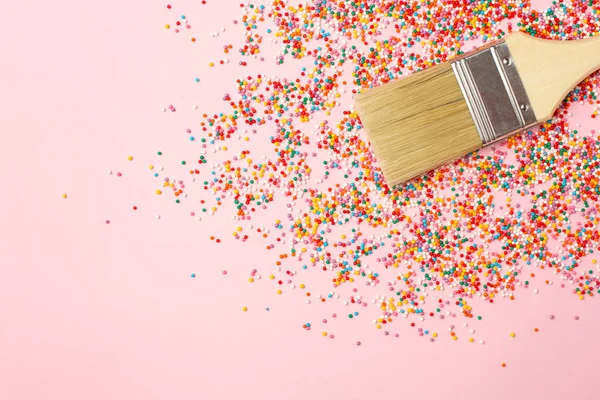 Cepillo y multicolor redondo rematando confeti para dulces, colorido fondo macro. Sabroso concepto de dulces y postres — Foto de Stock