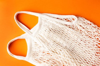 Turuncu arka planda pamuk alışverişi çevre dostu çanta, sıfır atık ve plastik serbest konsept operasyon görünümü.