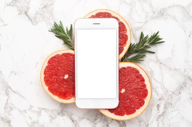 Mermer arka planda biberiyeli cep telefonu ve greyfurt, meyve ve teknoloji düz tabaka, yaz için en düşük kompoziton üst görünümde