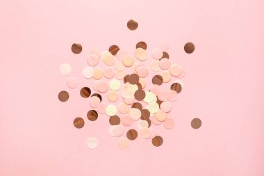 Pembe, altın ve sarı konfeti. Pembe renkli arka plan. Üst görünüm düşük.