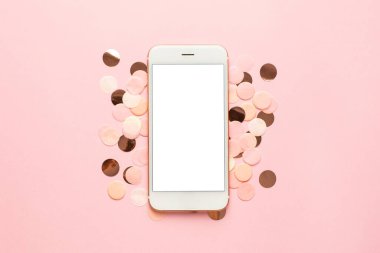 Pembe, altın ve sarı konfetili mobil telefon. Pembe renkli kağıttan arka plan minimal tarz üst görünüm.