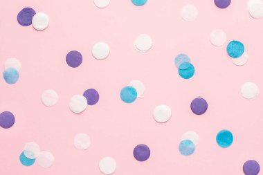 Pembe renkli kağıtta mavi, beyaz ve eflatun konfeti. Arka plan minimal stil üst görünüm
