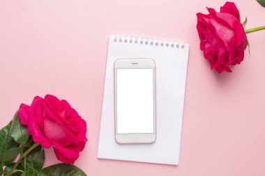 Cep telefonu ve pembe arka plan manzaralı koyu pembe gül.