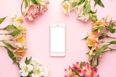 Cep telefonu ve pembe arka plan manzaralı sarı ve pembe çiçekler.