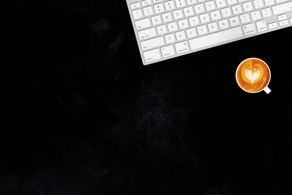 Tastatur und Tasse Kaffee Latte auf schwarzem Hintergrund — Stockfoto