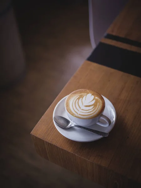 Csésze kávé latte art a fa íróasztal kávézó-kávézó — Stock Fotó