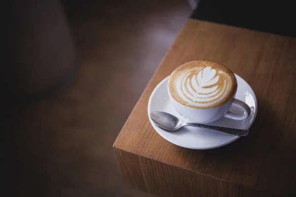 Csésze kávé latte art a fa íróasztal kávézó-kávézó — Stock Fotó