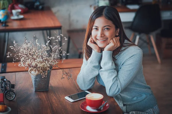 Asiatiska företag flicka arbeta och dricka kaffe i café med lap — Stockfoto