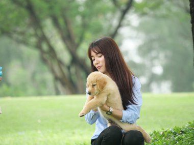 Asyalı erkek ve kız wiyh yavru köpek parkta oynarken