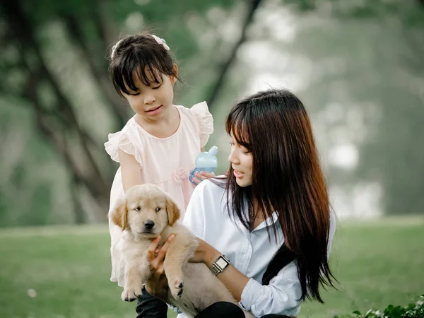 Asyalı erkek ve kız wiyh yavru köpek parkta oynarken — Stok fotoğraf