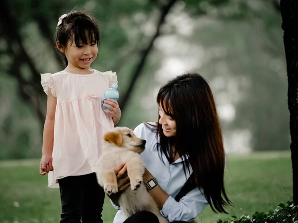 Asyalı erkek ve kız wiyh yavru köpek parkta oynarken — Stok fotoğraf