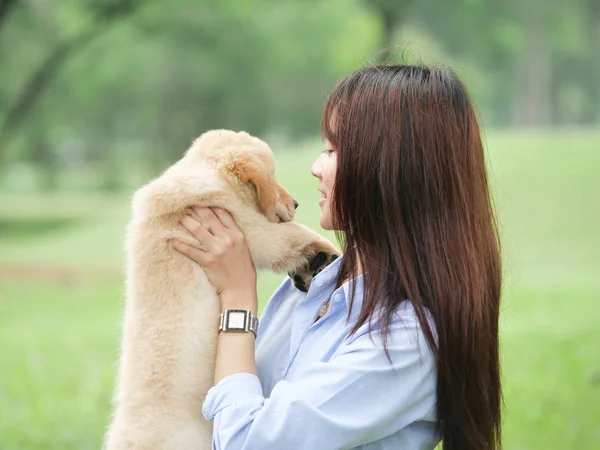 Asiatin spielt Welpe im Park — Stockfoto