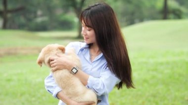 Asyalı kadın parkta köpek yavrusu oynamak