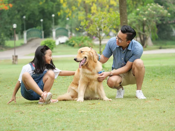 Ασιατική άνθρωπο και κορίτσι με σκύλο golden retriever στο πάρκο — Φωτογραφία Αρχείου