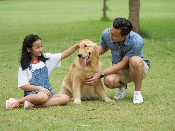 アジア人男性と公園内犬ゴールデン レトリーバーを持つ少女 — ストック写真