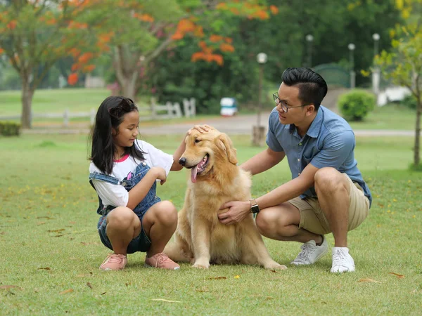 Ασιατική άνθρωπο και κορίτσι με σκύλο golden retriever στο πάρκο — Φωτογραφία Αρχείου
