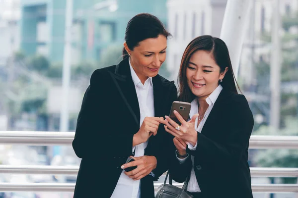 Dos mujeres de negocios hablando juntas al aire libre . — Foto de Stock