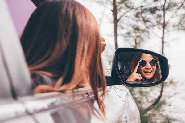 Asiatisk kvinna smilng med spegeln i bilen. — Stockfoto
