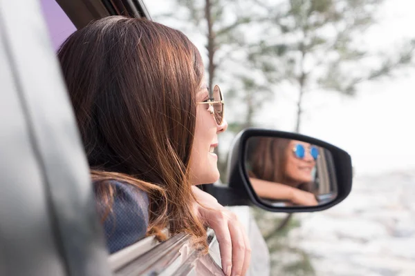 Mujer asiática sonriendo con el espejo en el coche . —  Fotos de Stock