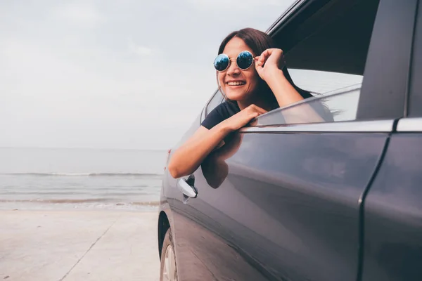 Mulher asiática sorrindo com o espelho no carro . — Fotografia de Stock