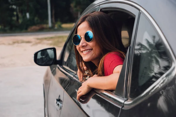 Mulher asiática sorrindo com o espelho no carro . — Fotografia de Stock