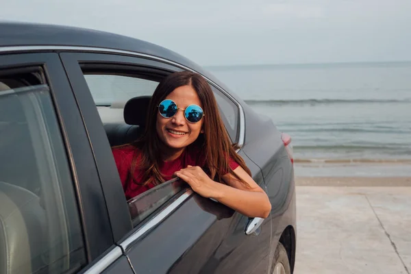 Mujer asiática sonriendo con el espejo en el coche . —  Fotos de Stock