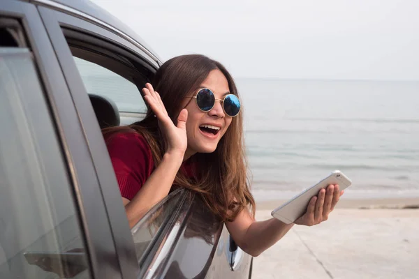 Mujer asiática sonriendo con el espejo en el coche . —  Fotos de Stock